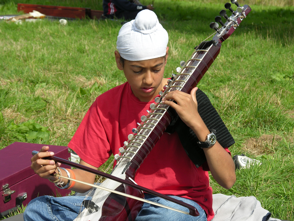 a boy playing a dilruba